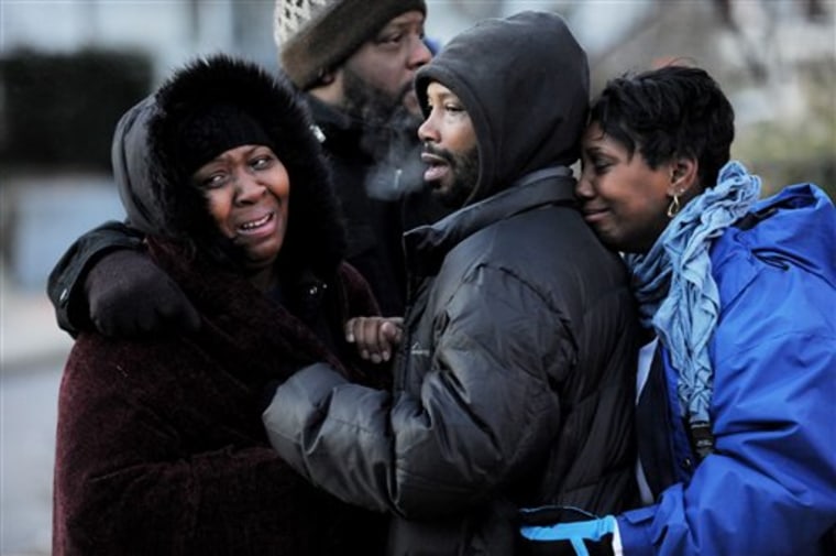 Family members of six people who died in an early morning two-alarm fire gather near the scene of the blaze in East Baltimore, Md. Tuesday, Dec. 14, 2010.  Six people died in one of the three houses heavily damaged in the the blaze. (AP Photo/Baltimore Sun, Kim Hairston)